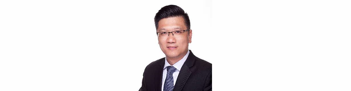 Portrait of Lee Seng Meng, man smiling in a business suit wearing a tie and glasses